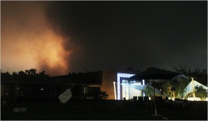 De la fumée rose s'échappe de bâtiments suite à des bombardements aériens à Tripoli